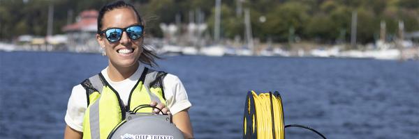 Ashley runs equipment on boat on lake
